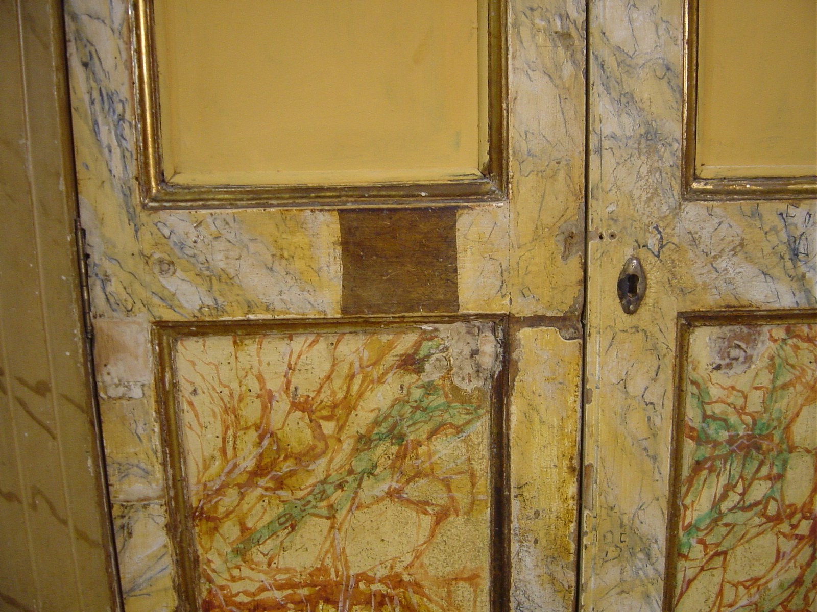 Detall de la porta amb marbrejat abans de la restauració, amb pèrdues i brutícia