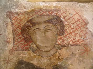 La mateixa pintura mural amb el rostre recuperat després de la restauració
